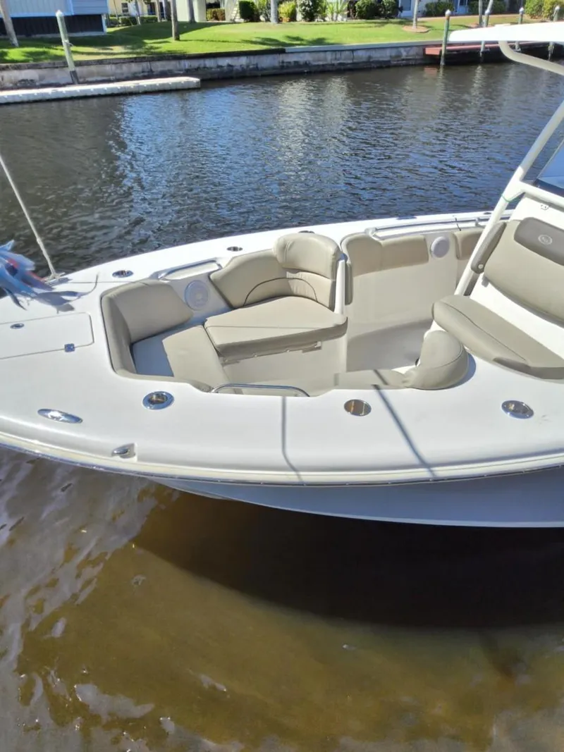 Slide: The Image of 2021 Key West 263 FS boat with spacious seating, docked by a calm waterfront. - 1