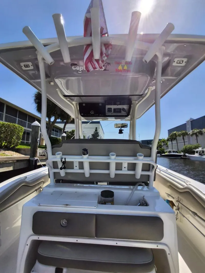 Slide: The Image of 2021 Key West 263 FS boat interior with rod holders and seating, docked by a canal. - 11