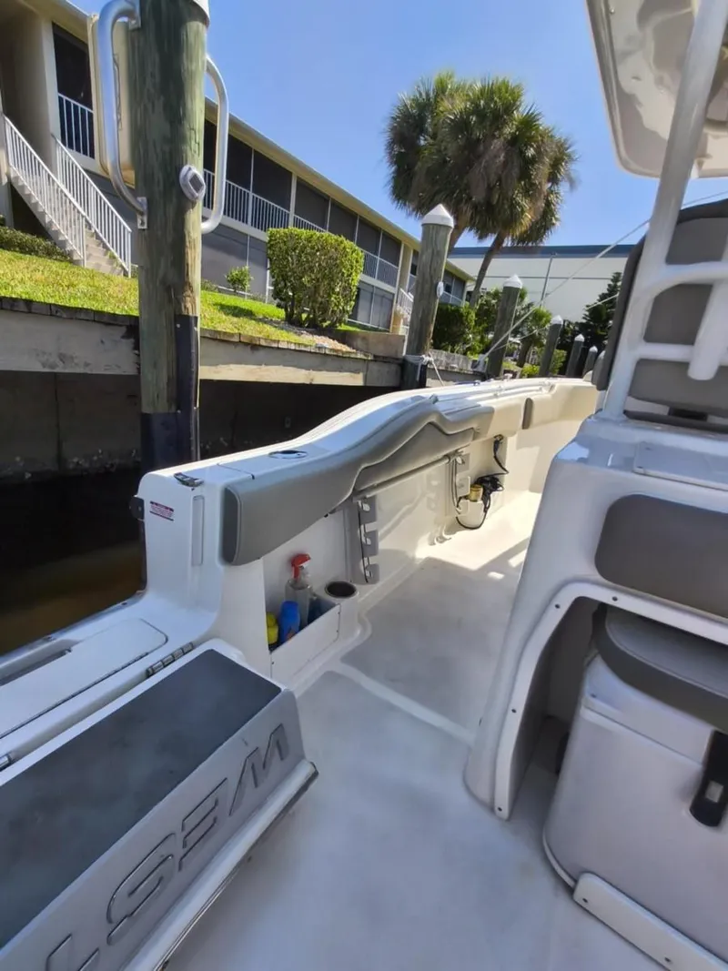 Slide: The Image of 2021 Key West 263 FS boat docked, featuring spacious deck and storage compartments. - 13
