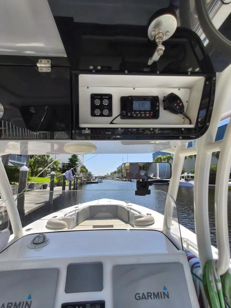 Slide: The Image of 2021 Key West 263 FS boat interior with Garmin electronics, docked in a scenic canal. - 15