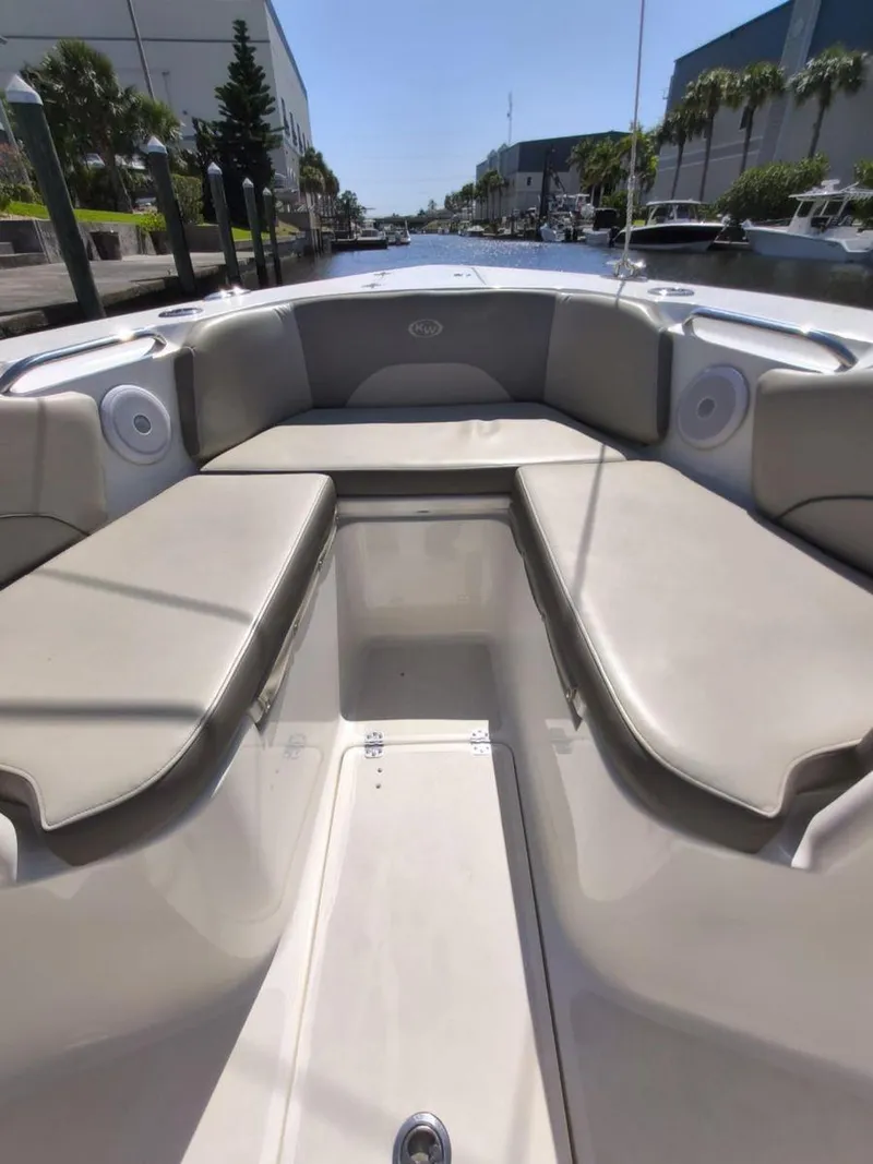 Slide: The Image of 2021 Key West 263 FS boat interior with beige seating, docked in a marina. - 16