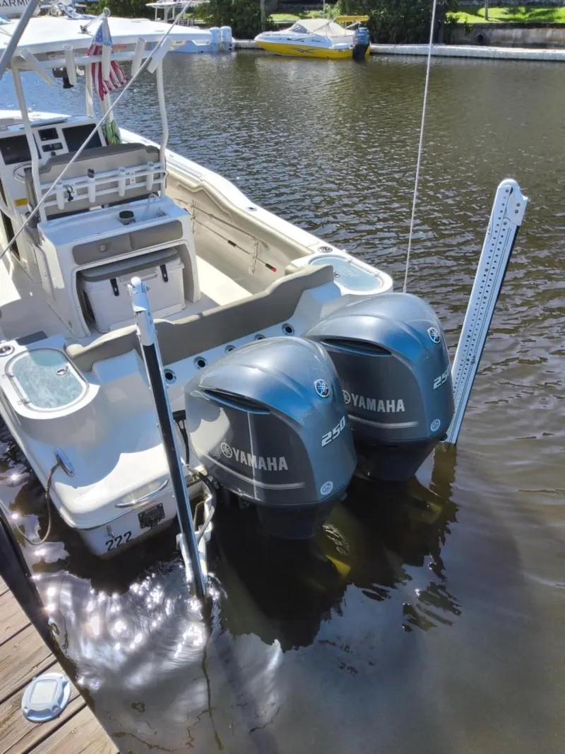 Slide: The Image of 2021 Key West 263 FS boat with dual Yamaha outboard engines docked on calm water. - 3