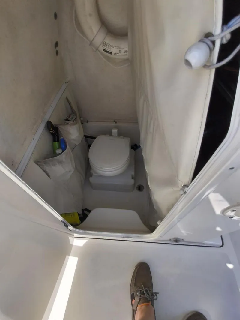 Slide: The Image of 2021 Key West 263 FS boat interior with compact marine toilet and storage. - 5