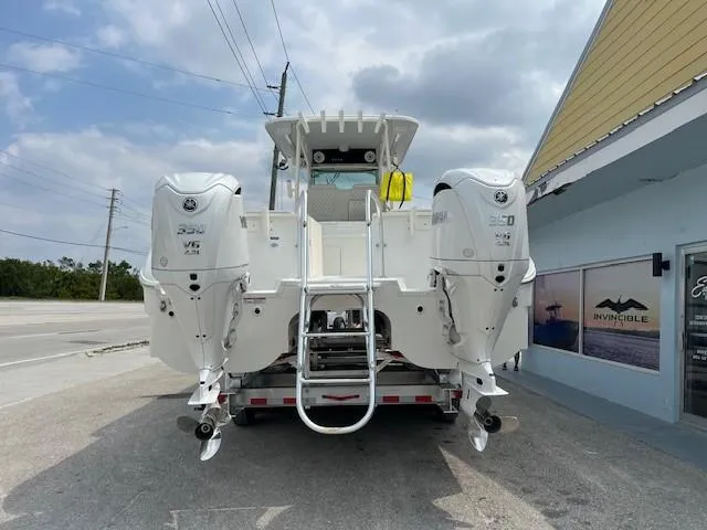 Slide: The Image of 2025 World Cat 325 CC boat with twin engines, parked outside a building. - 2