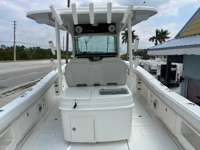 Slide: The Image of 2025 World Cat 325 CC boat interior with seating and storage, docked near a road. - 6