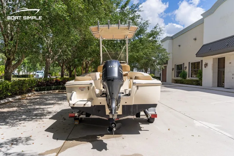 Slide: The Image of 2022 Scout 195 Sportfish boat on trailer, parked outdoors near buildings. - 3