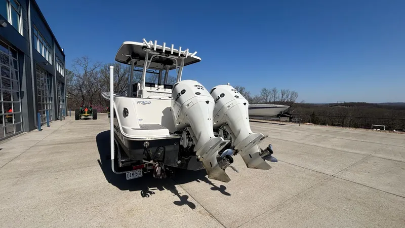 Slide: The Image of 2021 Robalo R302 CC boat with dual outboard engines on a sunny day. - 10