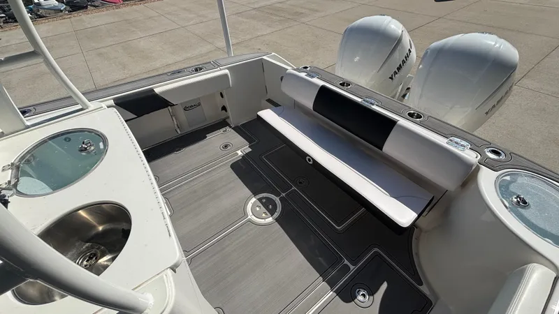 Slide: The Image of 2021 Robalo R302 CC boat interior with seating, sink, and twin engines. - 13
