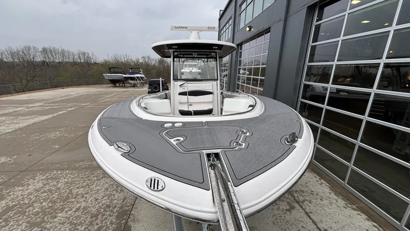Slide: The Image of 2021 Robalo R302 CC boat docked near a modern building. - 6