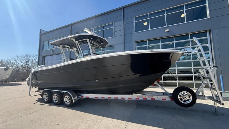 Slide: The Image of 2021 Robalo R302 CC boat on trailer outside modern building. - 8
