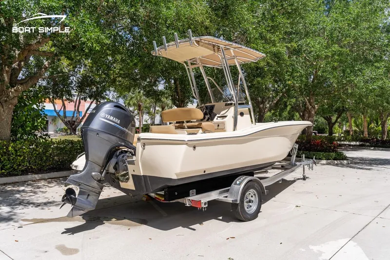 Slide: The Image of 2022 Scout 195 Sportfish boat with Yamaha engine on trailer, parked outdoors. - 2