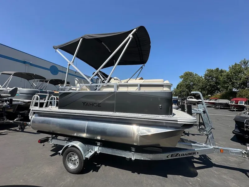 The Image of 2025 Tahoe Pontoon Sport Cruise 15' on trailer, with canopy, in outdoor setting. - 0