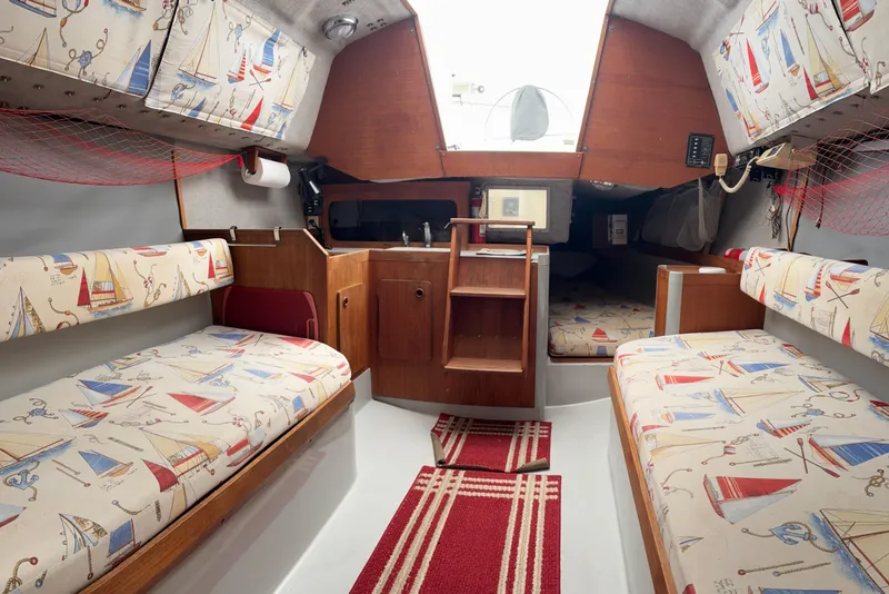 Slide: The Image of Interior of a 1989 O'Day 272 sailboat with nautical-themed upholstery. - 10