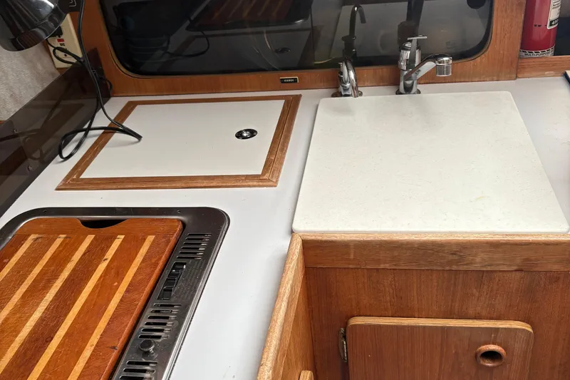 Slide: The Image of 1989 O'Day 272 sailboat galley with sink, cutting board, and storage. - 12