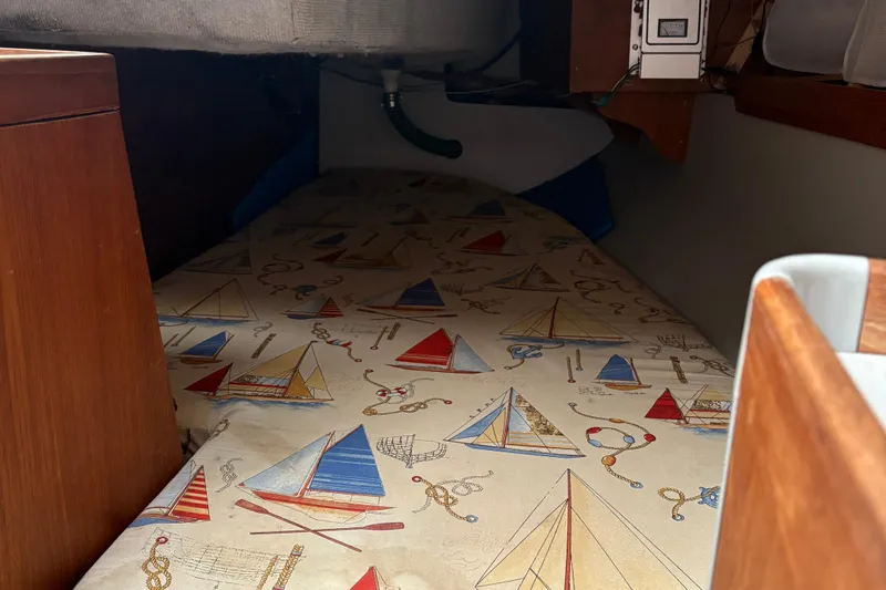 Slide: The Image of Interior of a 1989 O'Day 272 sailboat with nautical-themed bedding. - 17