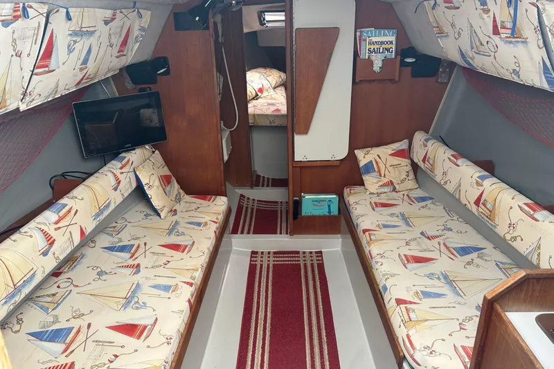 Slide: The Image of Interior of a 1989 O'Day 272 sailboat with nautical-themed upholstery and cozy seating. - 5