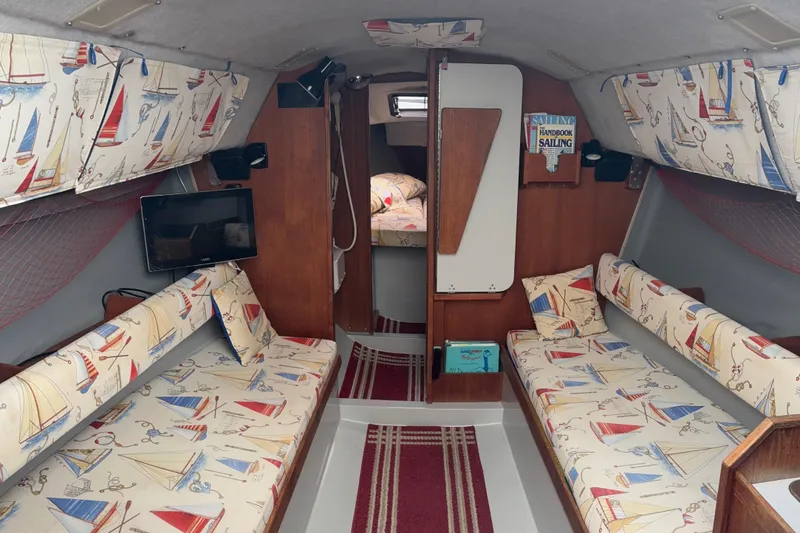 Slide: The Image of Interior of 1989 O'Day 272 sailboat with nautical-themed upholstery and cozy cabin layout. - 6
