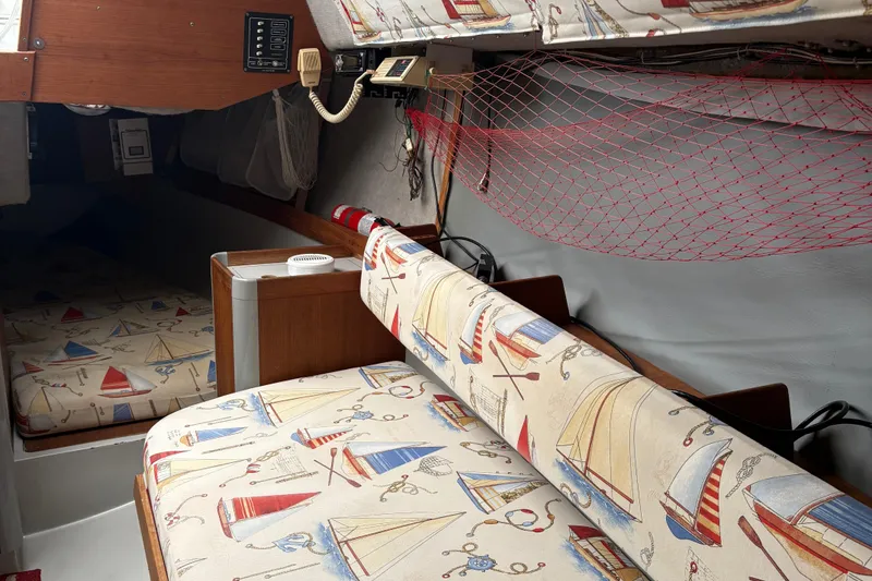 Slide: The Image of Interior of a 1989 O'Day 272 sailboat with nautical-themed upholstery. - 7