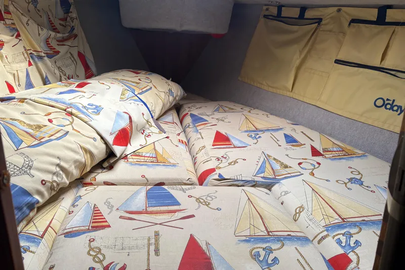 Slide: The Image of Cozy cabin interior of 1989 O'Day 272 sailboat with nautical-themed bedding. - 8