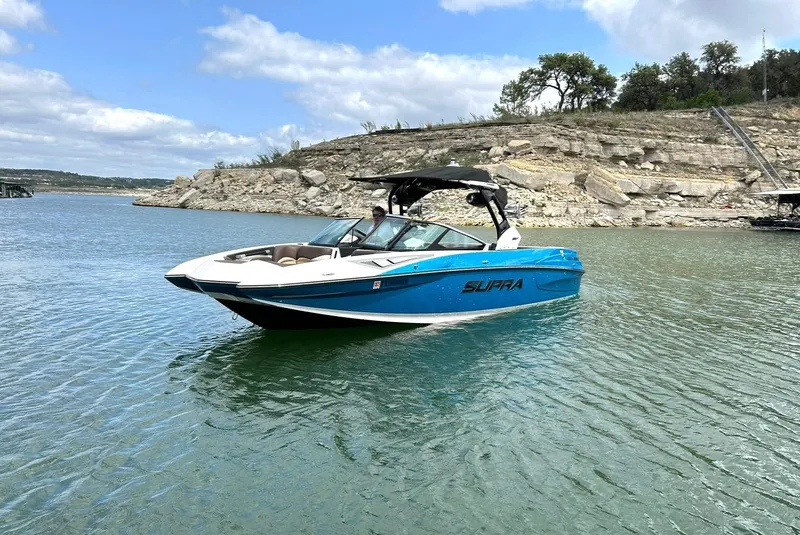 Slide: The Image of 2017 Supra SE 550 boat on a serene lake with rocky shoreline. - 11