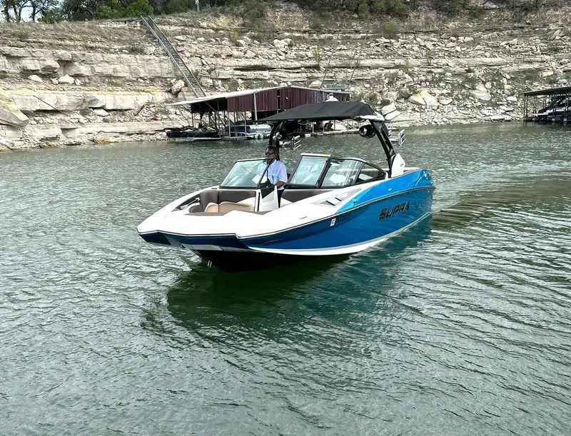 Slide: The Image of 2017 Supra SE 550 boat cruising on a lake with rocky shoreline. - 12