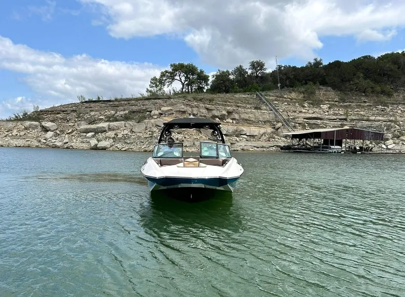 Slide: The Image of 2017 Supra SE 550 boat on a lake with rocky shoreline and cloudy sky. - 14