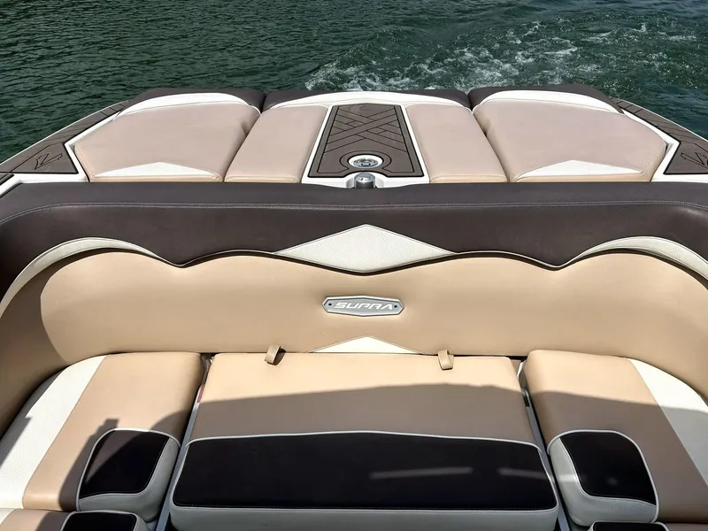 Slide: The Image of 2017 Supra SE 550 boat interior with beige and brown seating on water. - 21