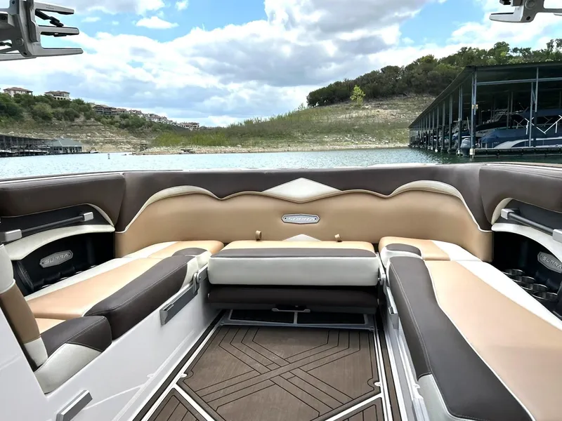Slide: The Image of 2017 Supra SE 550 boat interior with luxurious seating, docked by a scenic lake. - 28