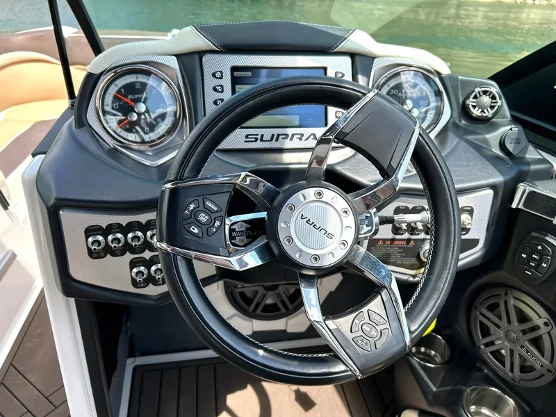 Slide: The Image of Steering wheel and dashboard of 2017 Supra SE 550 boat, featuring modern controls and gauges. - 40