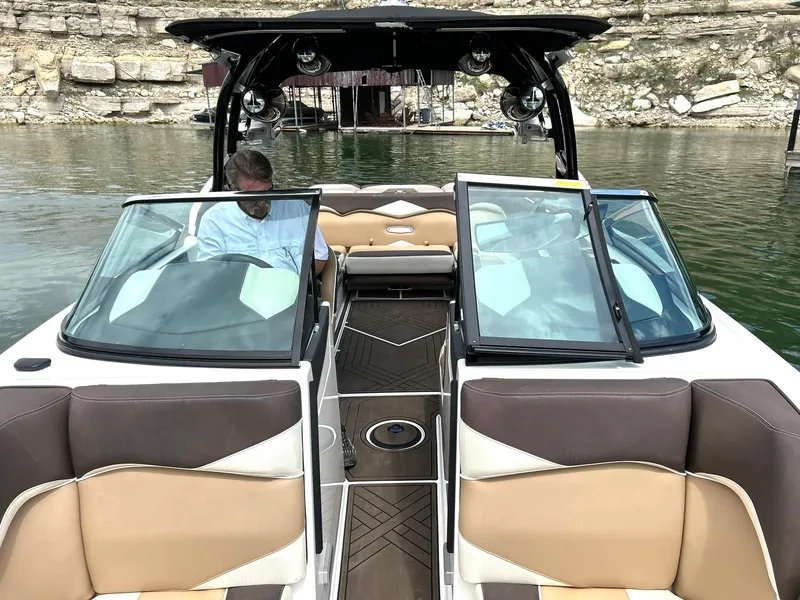 Slide: The Image of 2017 Supra SE 550 boat with open cockpit, docked on a calm lake. - 46