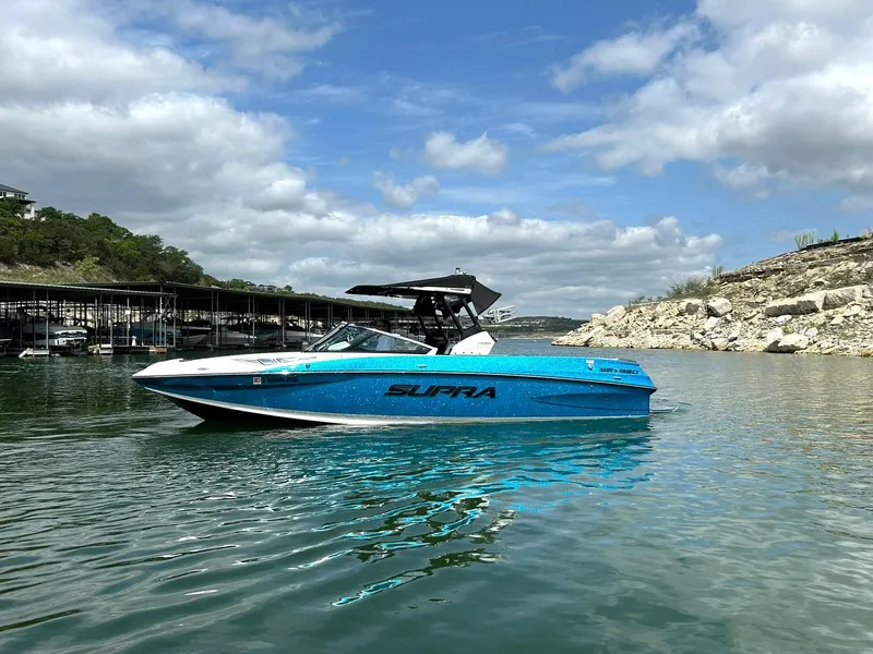Slide: The Image of 2017 Supra SE 550 boat on a calm lake under a partly cloudy sky. - 9