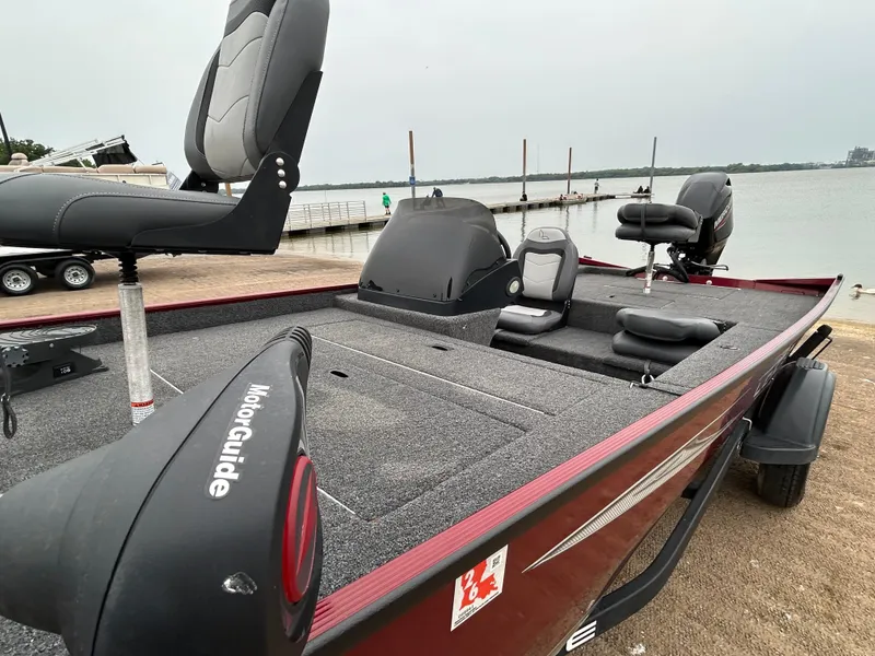 Slide: The Image of 2022 Lowe Skorpion 17 fishing boat docked by the lake, featuring comfortable seating and MotorGuide trolling motor. - 14