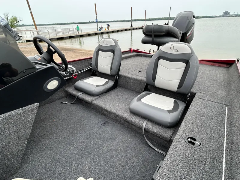 Slide: The Image of 2022 Lowe Skorpion 17 boat interior with two seats, steering wheel, and lake view. - 15