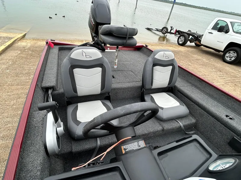 Slide: The Image of 2022 Lowe Skorpion 17 boat interior with dual seats and steering wheel by the water. - 16