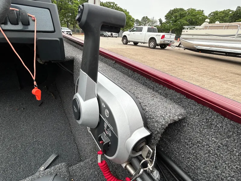 Slide: The Image of Throttle control of 2022 Lowe Skorpion 17 boat, with parking lot and vehicles in background. - 29