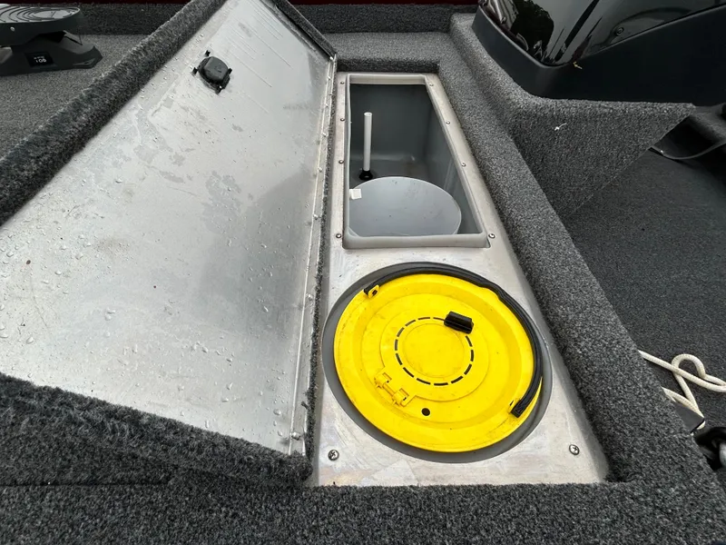 Slide: The Image of 2022 Lowe Skorpion 17 boat storage compartment with open hatch and yellow lid. - 39