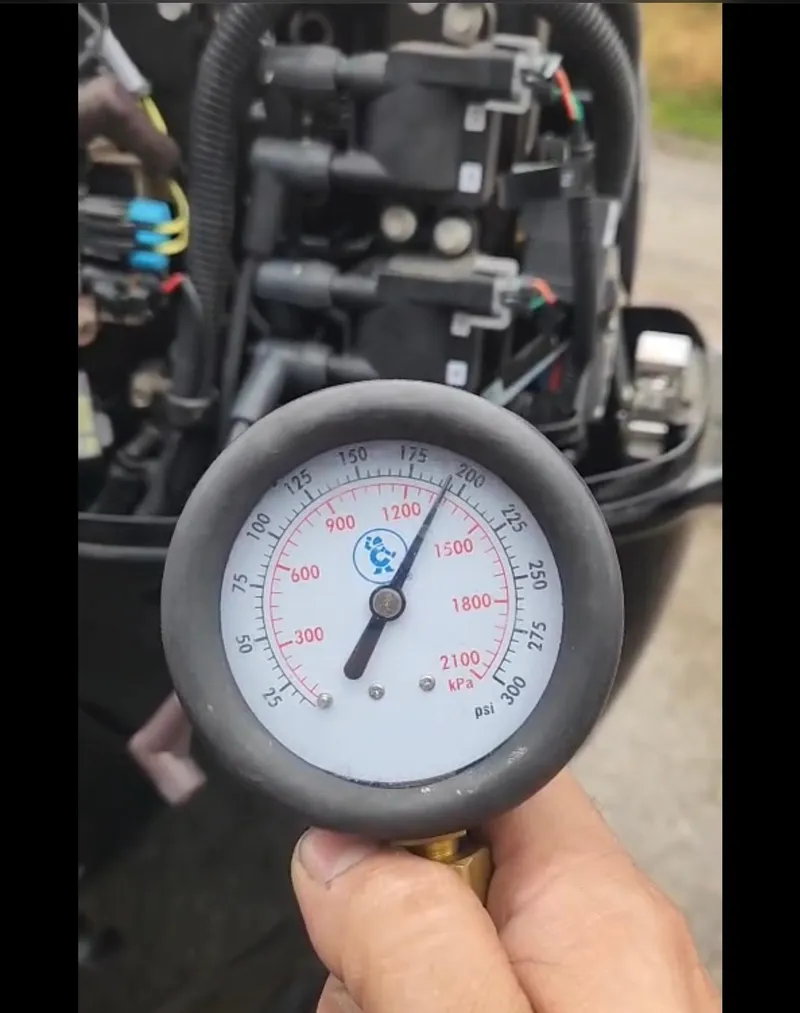 Slide: The Image of Hand holding a pressure gauge near a Lowe Skorpion 17 engine, 2022 model. - 42