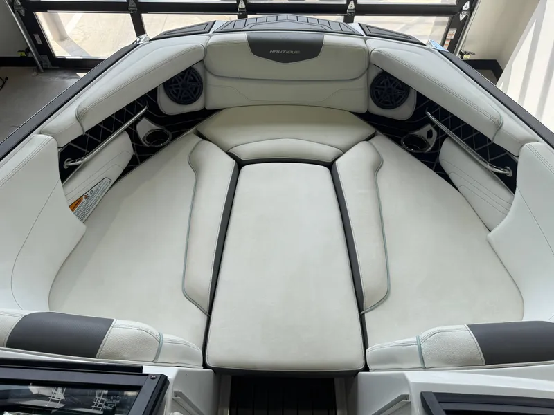 Slide: The Image of 2019 Nautique Super Air Nautique GS22 interior with white cushioned seating and speakers. - 15