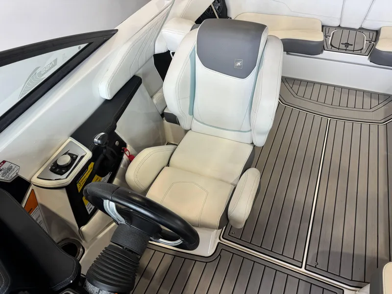Slide: The Image of 2019 Nautique Super Air Nautique GS22 interior with captain's seat and steering wheel. - 19