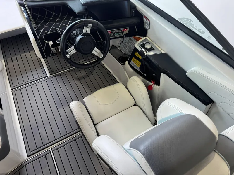 Slide: The Image of 2019 Nautique Super Air Nautique GS22 cockpit with steering wheel and seating. - 23