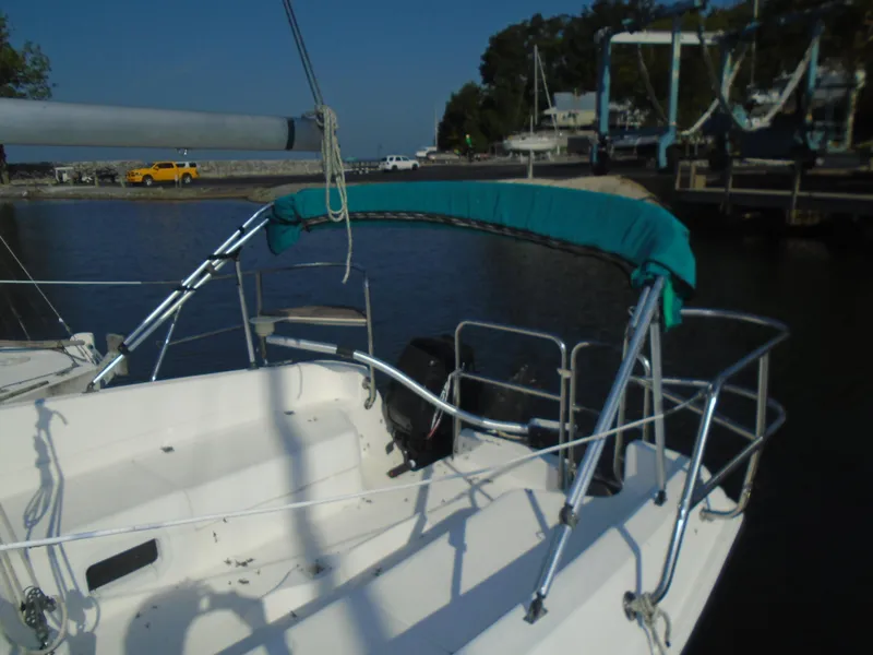 Slide: The Image of 1996 Hunter 23.5 sailboat docked at marina with green canopy. - 2