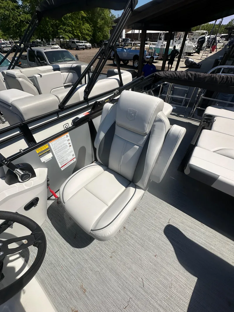 Slide: The Image of 2025 Godfrey Sweetwater 2286 SFLC boat interior with plush seating and steering wheel. - 22