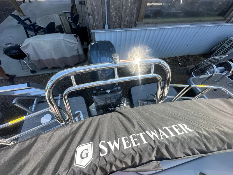 Slide: The Image of 2025 Godfrey Sweetwater 2286 SFLC boat with protective cover and shiny metal railing. - 27