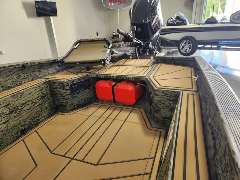 Slide: The Image of 2025 Tracker Grizzly 1650 T Prairie Wings Edition boat interior with camouflage design and red fuel tank. - 10