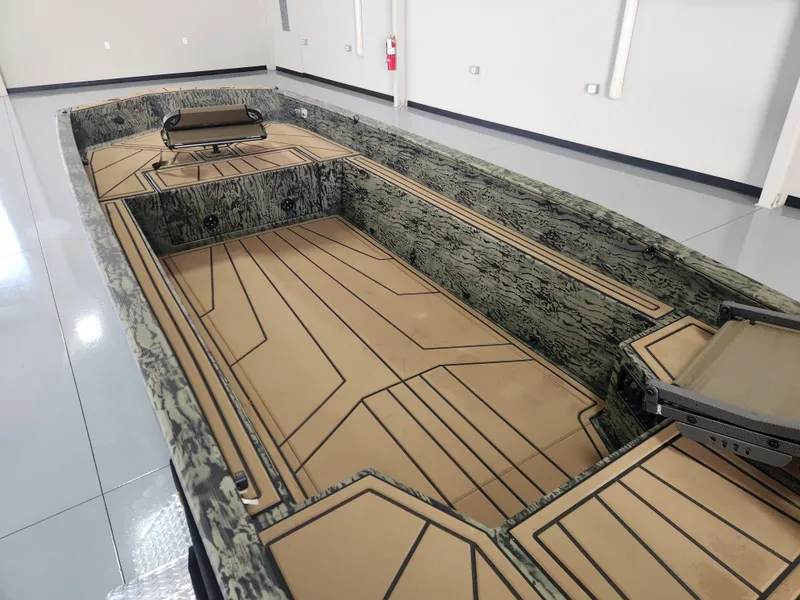 Slide: The Image of 2025 Tracker Grizzly 1650 T Prairie Wings Edition boat with camo interior in a showroom. - 11