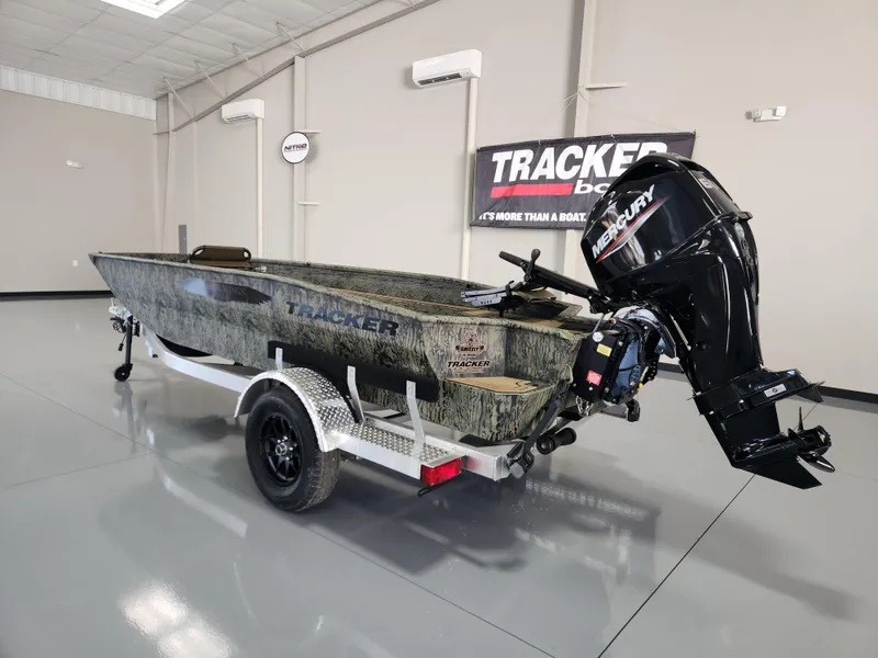 Slide: The Image of 2025 Tracker Grizzly 1650 T Prairie Wings Edition boat on trailer in showroom. - 2