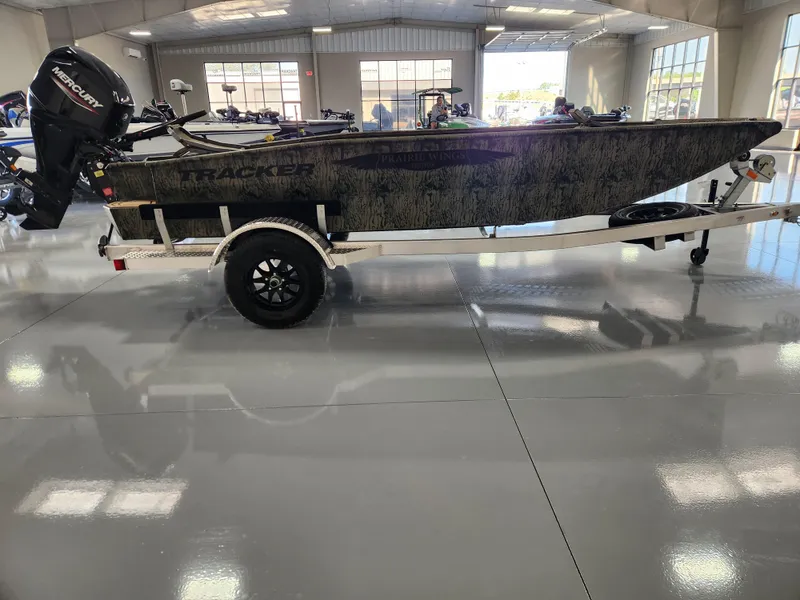 Slide: The Image of 2025 Tracker Grizzly 1650 T Prairie Wings Edition boat on trailer in showroom. - 5