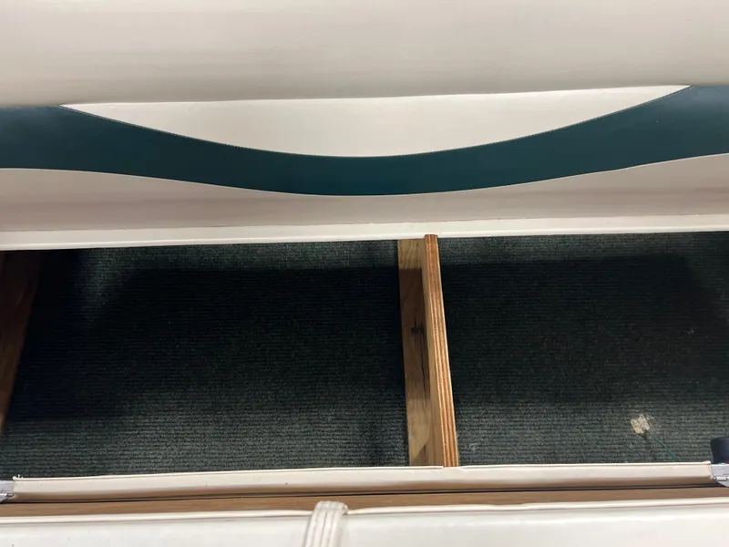 Slide: The Image of Open storage compartment in a 2008 Sweetwater 2386 RE boat, featuring wooden dividers. - 11