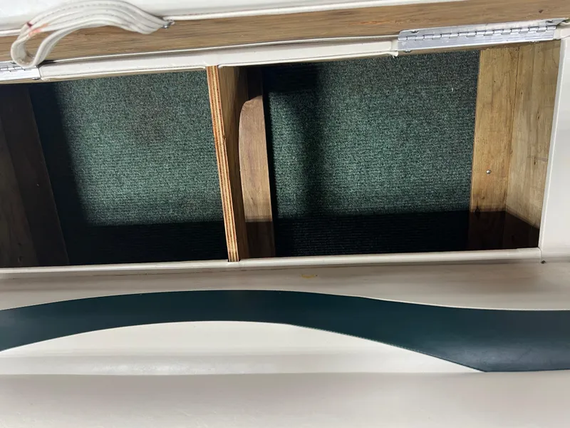 Slide: The Image of Open storage compartment in 2008 Sweetwater 2386 RE boat with green carpet interior. - 16