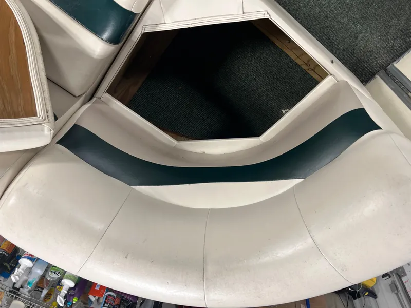 Slide: The Image of 2008 Sweetwater 2386 RE boat seat with white and green upholstery, showing storage compartment. - 17